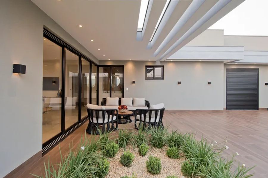 Escritório de arquitetura em Amambai MS: ambiente social com jardim interno de projeto residencial de alto padrão por Juliana Saraiva